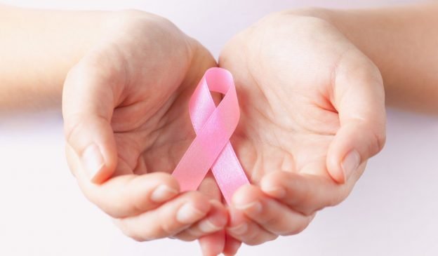 holding pink breast cancer awareness ribbon